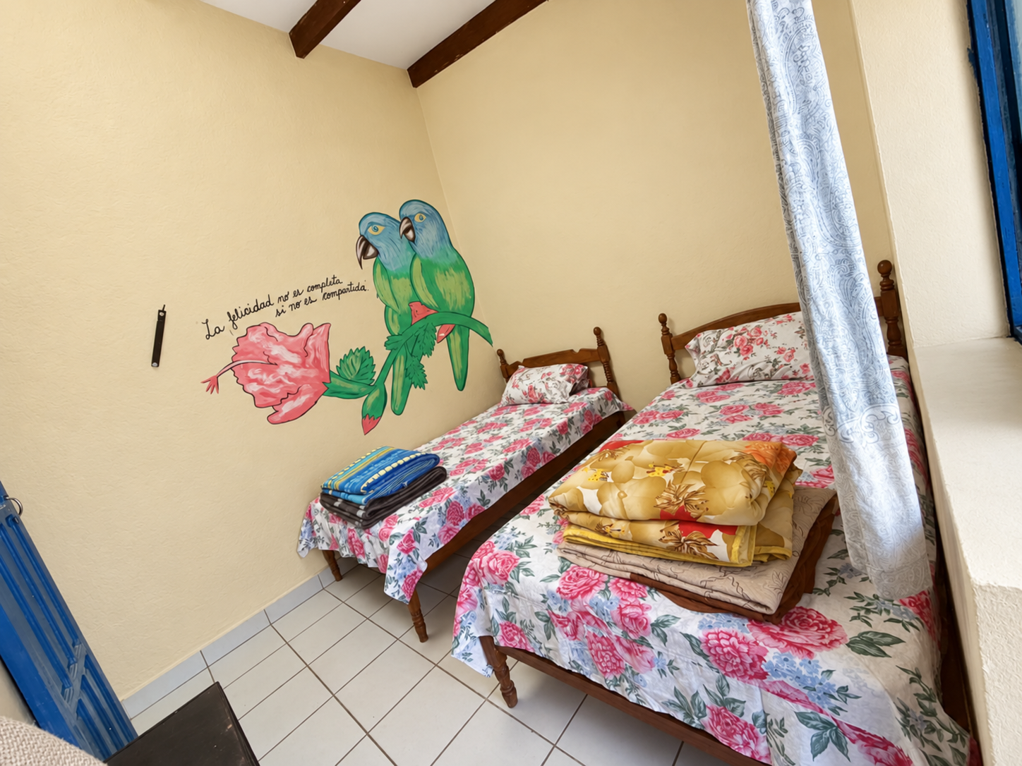 Habitación con dos camas y mural de aves
